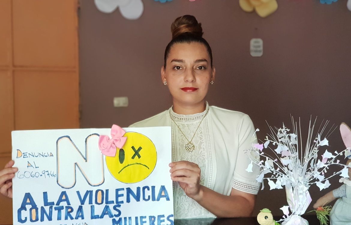 Frau mit Plakat, das auf die Hotline für Opfer von Gewalt aufmerksam macht.