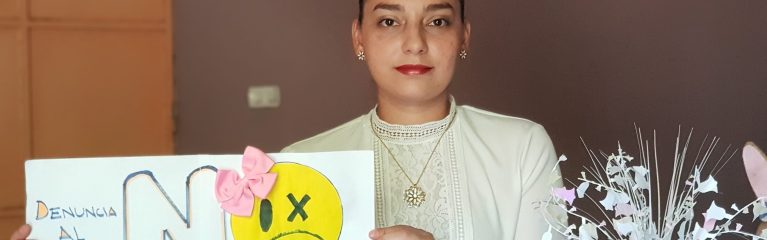 Frau mit Plakat, das auf die Hotline für Opfer von Gewalt aufmerksam macht.