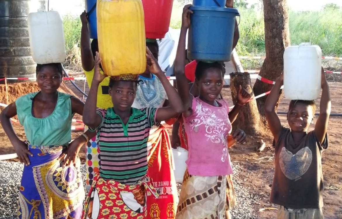 dav De jeunes filles portent des bidons d'eau dans un camp d'accueil d'urgence au Mozambique