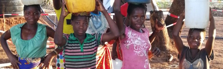 dav De jeunes filles portent des bidons d'eau dans un camp d'accueil d'urgence au Mozambique
