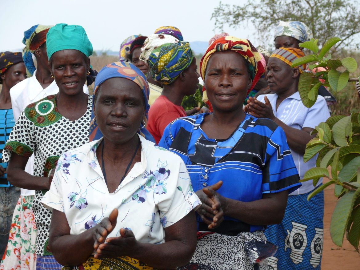 Frauen in Moçambique klatschen an einer Dorfversammlung Beifall