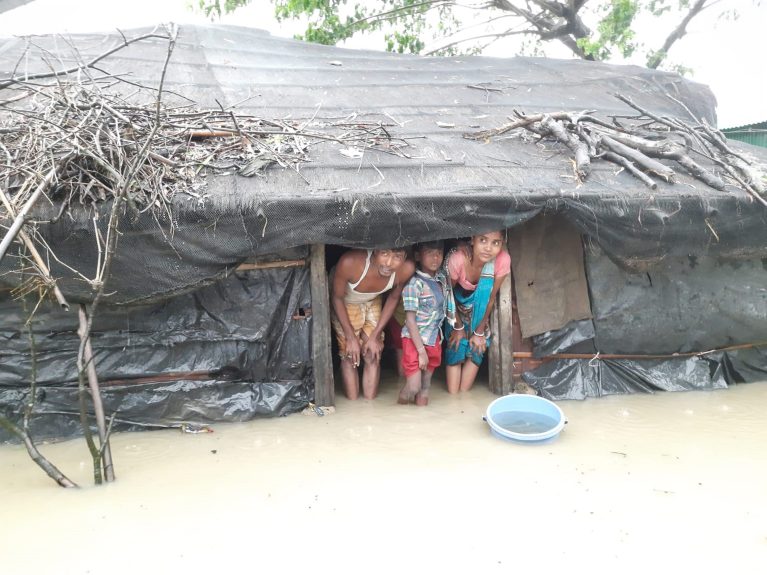 Geflüchtete warten in ihrer überfluteten Unterkunft darauf, evakuiert zu werden,