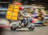 Motorradkurier*in in Bangkok bei der Auslieferung.